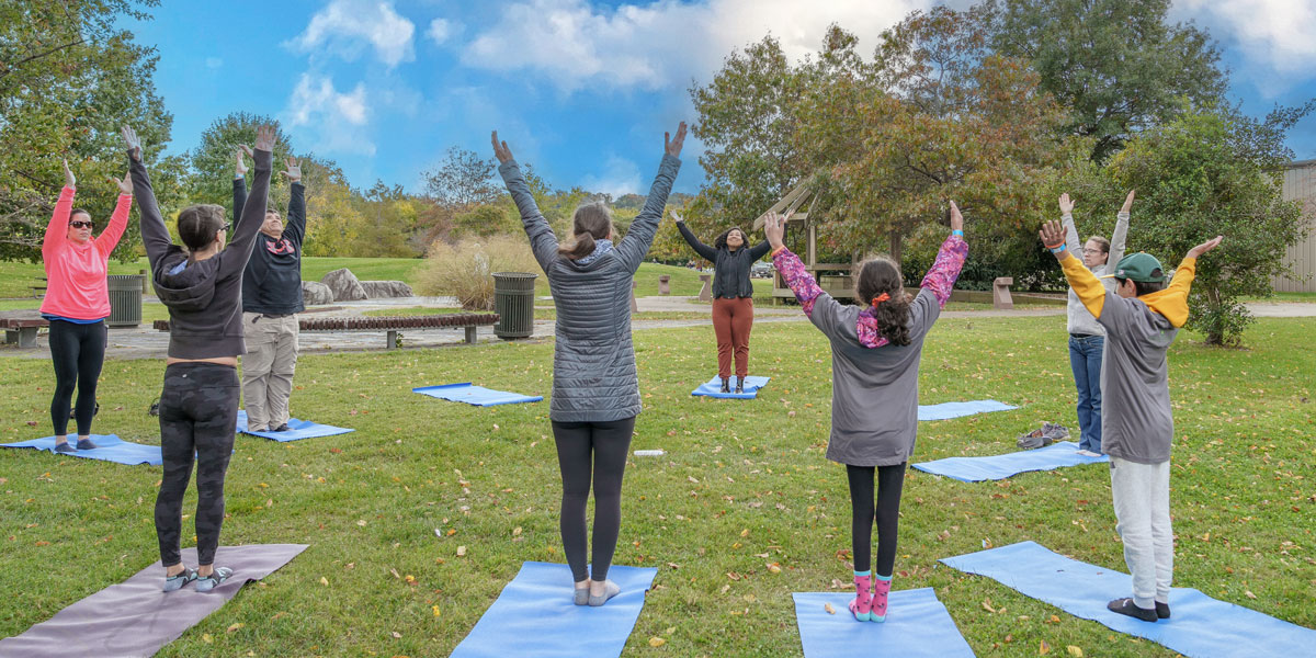 children and adults doing yoga outdoors