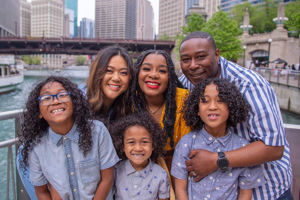 Jerilyn poses in front of the Chicago River with her husband and children.