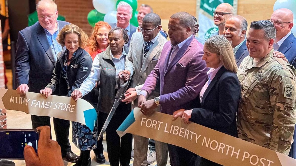 Kathy Roth-Douquet and others cutting banner at Fort Liberty Starbucks