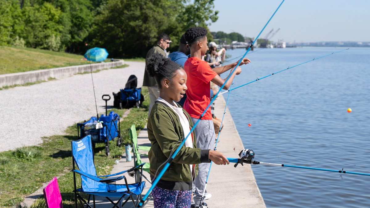 Blue Star Families members, including military children and adults fishing together during an outdoors experience.