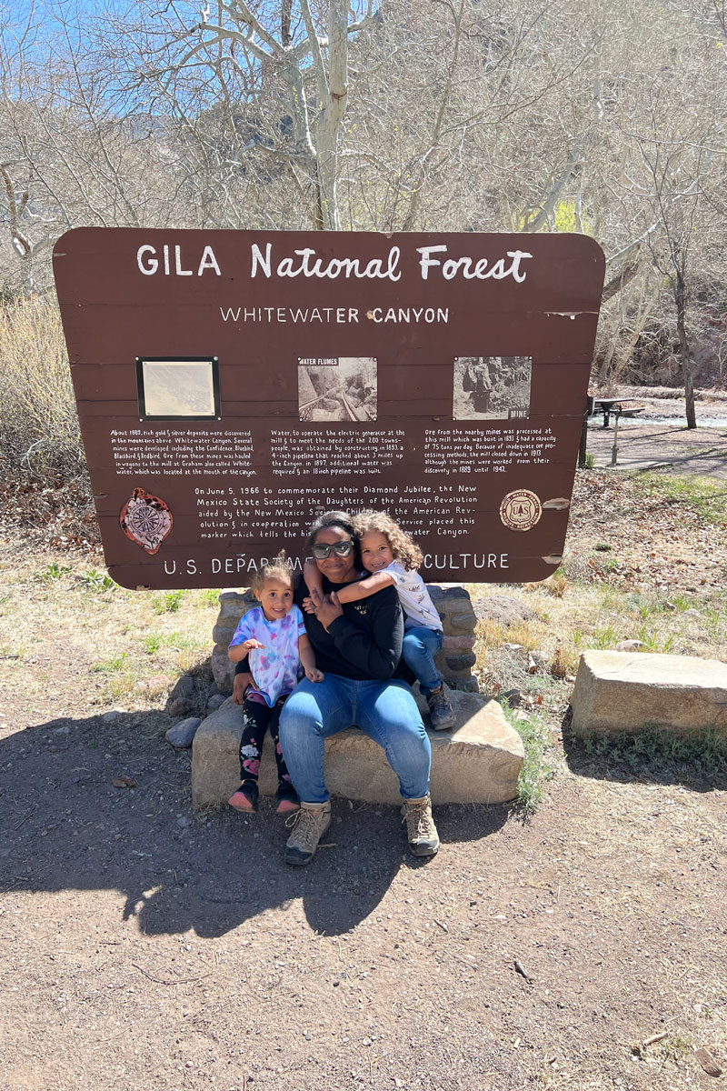 family posing in front of springs at Yellowstone National Park