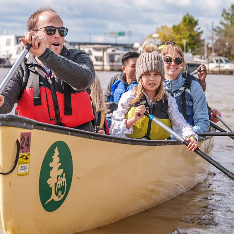 multiple families enjoying paddling in a canoe in the Anacostia River