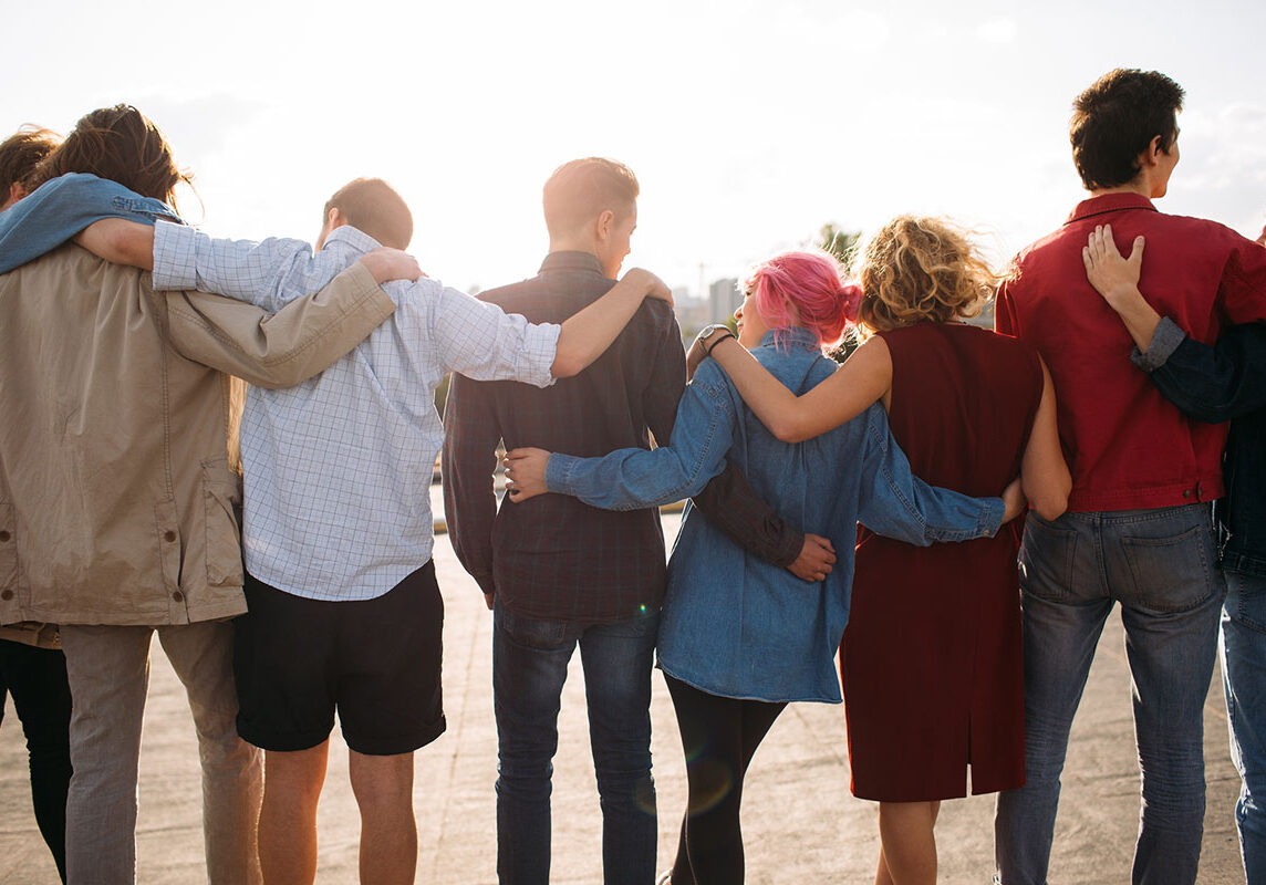 Group of adults with arms around each other showing support.