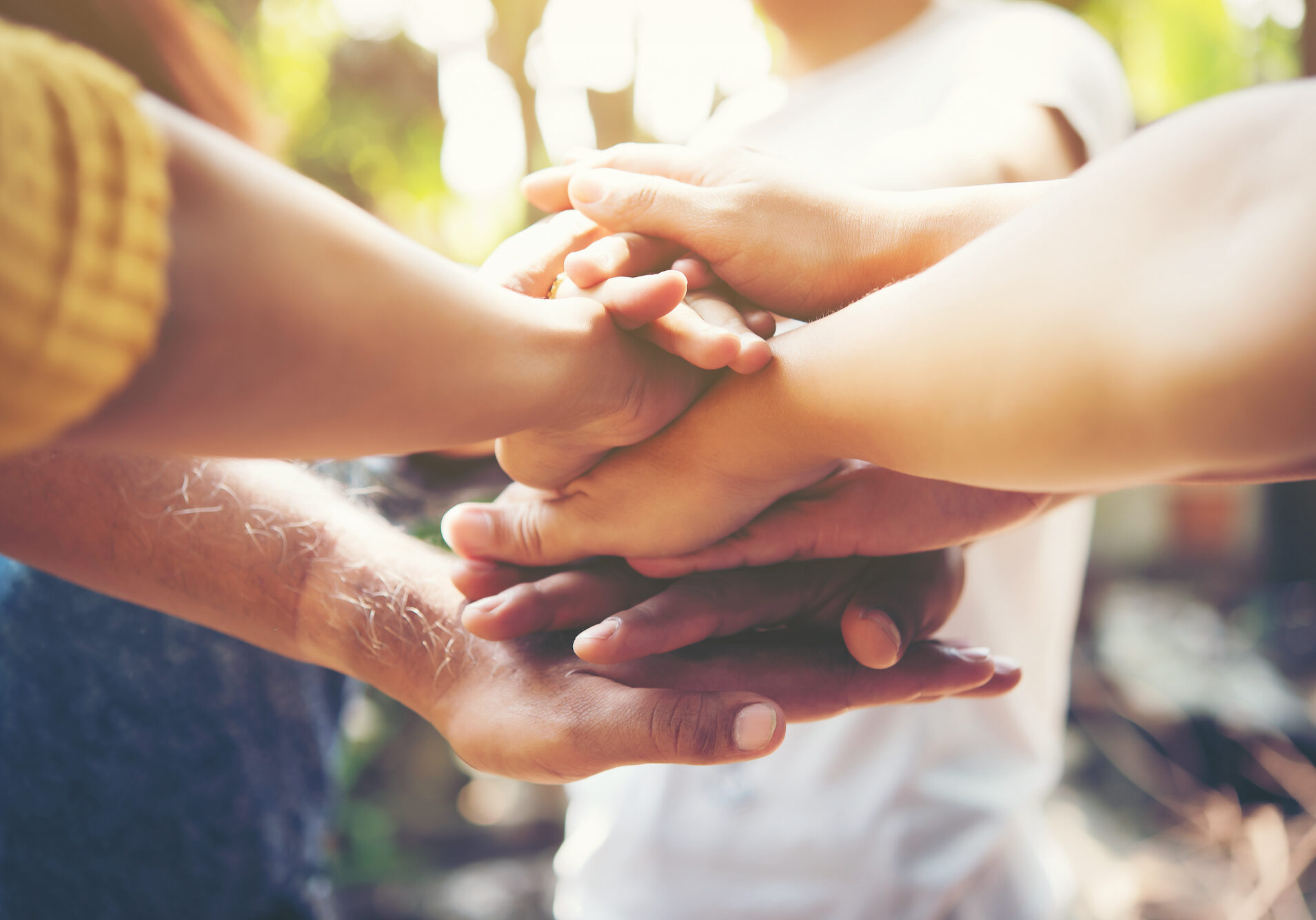 Close up of young people putting their hands together. Team with stack of hands showing unity and teamwork.